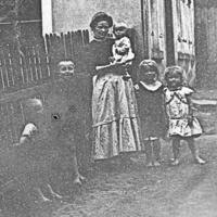 Emilie und Kinder am Haus, Gertrud auf Arm ca. 1913